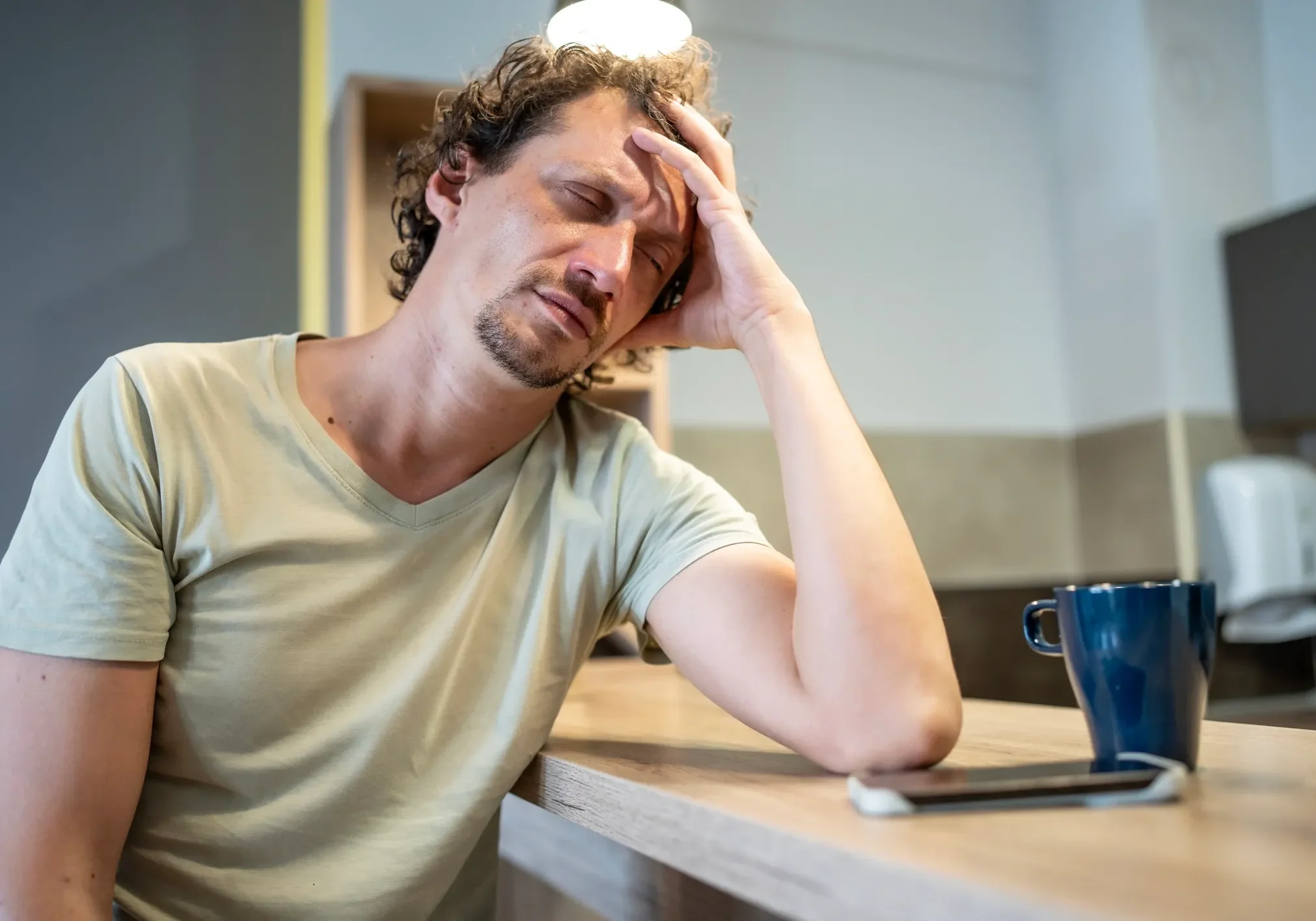 Man looking tired at a table.